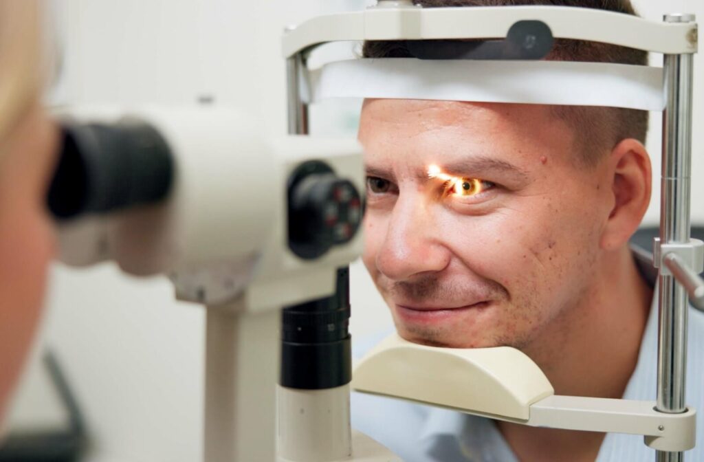 A person undergoing an eye examination with a slit-lamp machine, with a focused light shining into his eye.